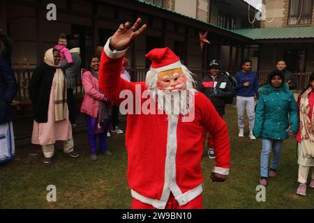 Srinagar Kaschmir, Indien. Dezember 2023. Ein Mann, der als Weihnachtsmann gekleidet ist, tanzt auf dem Gelände der katholischen Kirche der Heiligen Familie während der Weihnachtsfeiern in Srinagar. Der Weihnachtstag wird von Christen auf der ganzen Welt am 25. Dezember gefeiert, um die Geburt Jesu Christi zu gedenken. Am 25. Dezember 2023 In Srinagar Kaschmir, Indien. (Kreditbild: © Firdous Nazir/OKULARIS via ZUMA Press Wire) NUR REDAKTIONELLE VERWENDUNG! Nicht für kommerzielle ZWECKE! Stockfoto