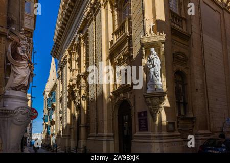 Blick auf die Straße von Valletta mit typischen Balkonen und Heiligenstatuen an den Hausfassaden. Valletta, Malta Stockfoto