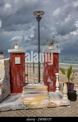 Ausstellung traditioneller Details, die in der griechischen Architektur verwendet werden. Tor mit rot lackierten Säulen. Mehrere Treppen. Blumentöpfe oben und daneben. S Stockfoto