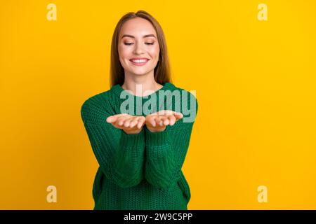 Porträt des jungen lächelnden Mädchenmodells genießen Sie Winterferien Vibes mit Weihnachtsdekoration, die Arme auf gelbem farbigen Hintergrund hält Stockfoto