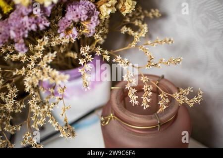 Nahaufnahme von blühenden lila, weißen und gelben kleinen Blüten in Vase. Getrocknete Blumen oder Ikebana für die Innendekoration. Stockfoto