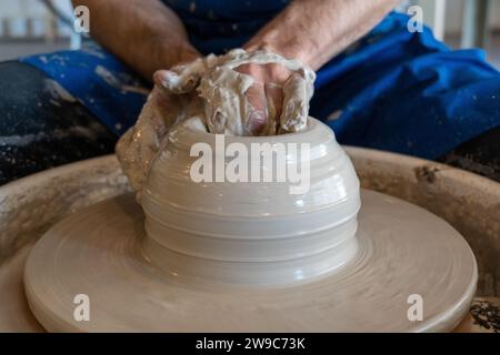 Potter wirft in einem Studio einen Topf aufs Steuer. Hochwertige Fotos. Hobby, Nebeneinander, Aktivität Stockfoto