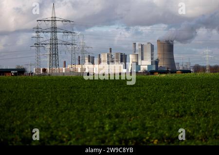 Impression vom RWE-Kraftwerk Bergheim Niederaußem. Das Kohlekraftwerk zieht seine Schwaden in die kalte Winterluft. In der Umgebung glänzen Strommasten, Windräder und Wolkenformationen in der kalten Wintersonne. Stadtwerke geben bekannt: Strompreise steigen für Privathaushalte 2024 um 32 Prozent. Grund ist eine Entscheidung der Bundesregierung, Gelder in Höhe von 5,5 Milliarden zur Stabilisierung der Netzentgelte zu streichen. Themenbild, Symbolbild. Bergheim, 26.12.2023 NRW Deutschland *** Eindruck von RWEs Kraftwerk Bergheim Niederaussem das Kohlekraftwerk bläst in den Kol Stockfoto