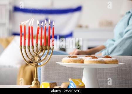 Menora mit Donuts und Dreidels für Hanukka auf dem Tisch, Nahaufnahme Stockfoto