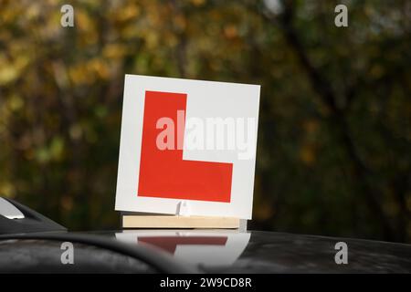 L-Schild auf dem Autodach im Freien. Fahrschule Stockfoto