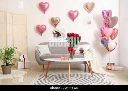 Das Innere des festlichen Wohnzimmers ist mit Ballons in Herzform und Rosenstrauß zum Valentinstag dekoriert Stockfoto