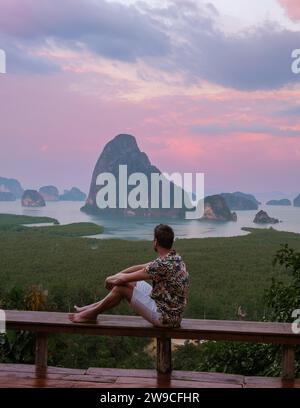 Ein Mann, der den Sonnenaufgang am Aussichtspunkt Phangnga Bay mit Mangrovenwald in der Andamanensee beobachtet, junger Mann am Reiseziel Sametnangshe in Phangnga, Thailand Stockfoto
