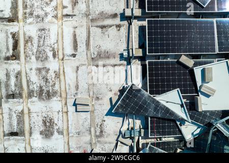 Draufsicht der durch den Hurrikan Ian zerstörten Photovoltaik-Solarpaneele, die auf dem Dach des Industriebaues zur Erzeugung von ökologischem Strom montiert sind Stockfoto