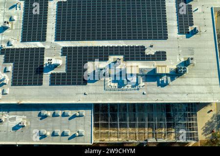 Erzeugung nachhaltiger Energie. Luftaufnahme eines Solarkraftwerks mit blauen Photovoltaikpaneelen auf dem Dach eines Industriebaums zur Produktion Stockfoto