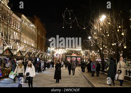 Sankt Petersburg, Russland. Dezember 2023. Die Menschen laufen auf dem Manezhnaya-Platz auf dem Weihnachtsmarkt zu Ehren des Neujahrs und Weihnachten. Quelle: SOPA Images Limited/Alamy Live News Stockfoto