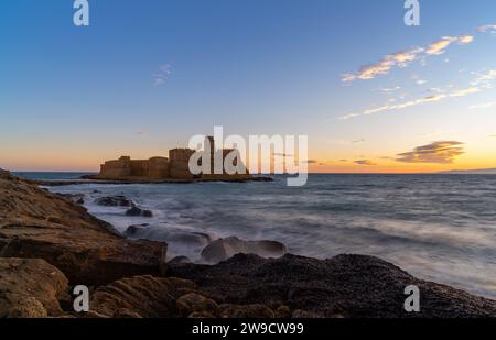 Le Castella, Italien - 11. Dezember 2023: Blick auf die Festung Le Castella in Isola di Capo Rizzuto bei Sonnenuntergang Stockfoto