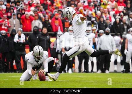 Daniel Carlson (2) schießt ein 24-Yard-Field-Tor aus dem Laderaum von Punter AJ Cole (6) im ersten Quartal während eines NFL Football-Spiels gegen die Kansas City Chiefs am Montag, 25. Dezember 2023, in Kansas City. Mo. Die Raiders besiegten die Chiefs mit 20:14. Stockfoto