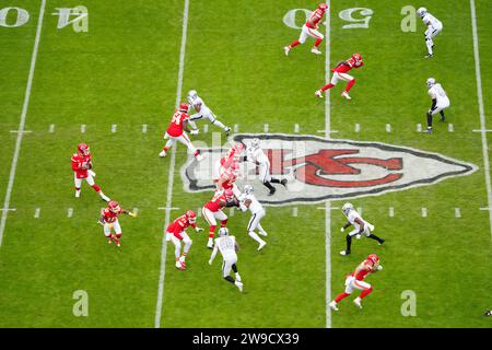 Eine allgemeine Gesamtbetrachtung, während der Quarterback der Kansas City Chiefs Patrick Mahomes (15) bei einem NFL Football-Spiel am Montag, den 25. Dezember 2023, in Kansas City gegen die Las Vegas Raiders im Mittelfeld vor der Schlagzeile des Chiefs-Logos schnappt. Mo. Die Raiders besiegten die Chiefs mit 20:14. Stockfoto