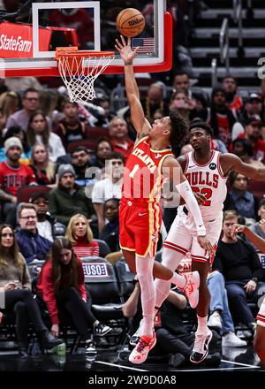 Chicago, USA. Dezember 2023. Jalen Johnson (L) von Atlanta Hawks geht während des regulären NBA-Saisonspiels zwischen den Atlanta Hawks und den Chicago Bulls am 26. Dezember 2023 in Chicago in den Warenkorb. Quelle: Joel Lerner/Xinhua/Alamy Live News Stockfoto