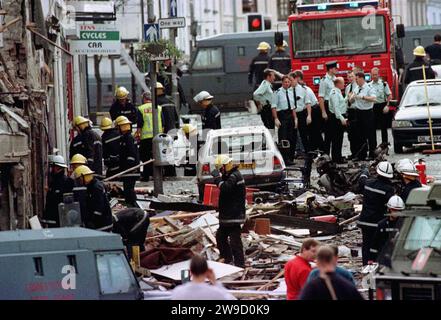 Foto vom 08/1998 von Polizisten und Feuerwehrleuten, die die durch eine Bombenexplosion verursachten Schäden in der Market Street, Omagh, inspizieren. Ein britischer Beamter äußerte Bedenken, dass die irische Präsidentin Mary McAleese an einer Gedenkfeier für die Opfer des Bombenanschlags von Omagh teilnehmen würde, als Königin Elisabeth II. Nicht anwesend war. 29 Menschen, darunter eine Frau, die mit Zwillingen schwanger war, wurden 1998 bei der Explosion einer Autobombe in der Stadt Co Tyrone getötet. Ausgabedatum: Mittwoch, 27. Dezember 2023. Stockfoto