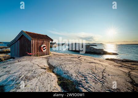 Holzhütte auf den Felsen im Naturschutzgebiet Tjurpannan im Archipel der schwedischen Westküste, beleuchtet von der Abendsonne Stockfoto