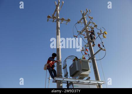 (231227) -- JISHISHAN, 27. Dezember 2023 (Xinhua) -- Mitarbeiter des State Grid arbeiten an einer vorübergehenden Siedlungsstätte in der Stadt Chuimatan in Jishishan, nordwestchinesische Provinz Gansu, 27. Dezember 2023. Bauarbeiter sind Tag und Nacht damit beschäftigt, Fertighäuser in Gansu zu bauen, damit Bewohner, die von einem Erdbeben der Stärke 6,2 betroffen sind, im Winter von Zelten in wärmere Bauwerke umziehen können. Nach Angaben des lokalen Büros für Wohnungsbau und städtisch-ländliche Entwicklung sollen bis Ende dieses Monats 15.000 solcher Häuser in den vom Erdbeben betroffenen Gebieten fertiggestellt sein. (Xinhua/Fang Xin) Stockfoto