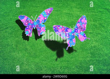 Zwei Schmetterlinge über einem grünen Rasen mit Schatten, die Flügel sind mit Blumen gemustert, Symbol für Naturschutz, Umweltschutz Stockfoto