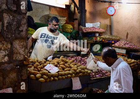 Port Louis, Mauritius - 25. Oktober 2023: Verkäufer, der Kartoffeln und Zwiebeln auf dem Central Market verkauft. Stockfoto