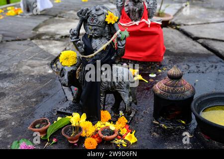 Shani Dev Hindu God Statue in Grand Bassin oder Ganga Talao, Mauritius mit Blumenopfer oder Opfer Stockfoto