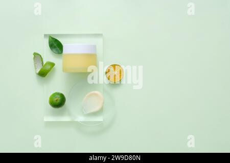 Modellverpackung, Kosmetikglas ohne Branding für Design, wird auf transparentem Podium mit Scheiben Kumquat angezeigt. Konzept zur Werbung für Naturkosmeti Stockfoto