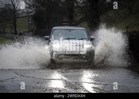 B6277, Middleton-in-Teesdale, Teesdale, County Durham, Vereinigtes Königreich. Dezember 2023. Wetter in Großbritannien. Die Fahrzeuge fahren auf der B6277 in der Nähe von Middleton-in-Teesdale durch Hochwasser, als der Sturm Gerrit Nordengland zu treffen beginnt. Quelle: David Forster/Alamy Live News Stockfoto