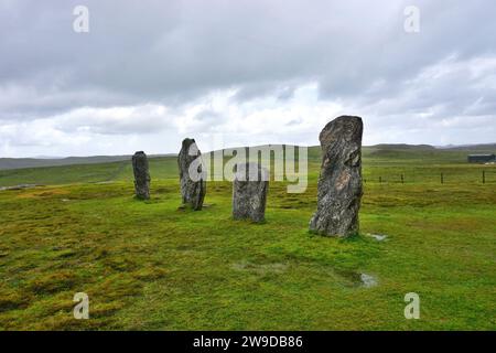 Ein Quartett aus alten stehenden Steinen steht im Kontrast zur hellgrünen Wiese an der neolithischen Stätte Callanish in einer abgelegenen Ecke von Lewis Island Schottland Stockfoto