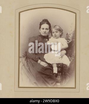 Studio Porträt von Mutter und Tochter, 1890 - 1920 Fotografie Studio Porträt von Mutter und Tochter. Die Mutter trägt ein schwarzes hochgeschlossenes Kleid mit einem Kragen, der mit einer Brosche verschlossen ist. Die Tochter trägt ein weißes Kleid, zusammen sitzen sie auf einem Stuhl. Das Haager Papier. Unterstützung für Fotos Stockfoto