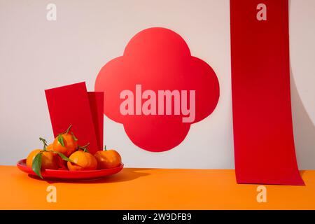 Eine Schale in roter Farbe mit Kuverts und Mandarinen auf. Die Chinesen haben vor, während und nach dem Neujahrsfest eine Menge Aktivitäten Stockfoto