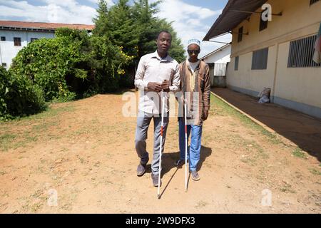 Zwei blinde Freunde helfen einander mit ihren weißen Stangen, indem sie zur Promenade gehen. Stockfoto