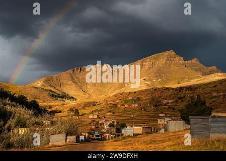 Regenbogen über den Bergen im Lesotho Dorf Daliwe Stockfoto