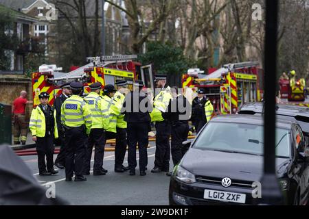 Feuerwehrfahrzeuge und Polizisten auf der Seagrave Road in Fulham, West London, während Feuerwehrleute in der London Oratory School eine Flamme angreifen. Im vierstöckigen Gebäude steht ein Atrium, sagte die Feuerwehr. Bilddatum: Mittwoch, 27. Dezember 2023. Stockfoto