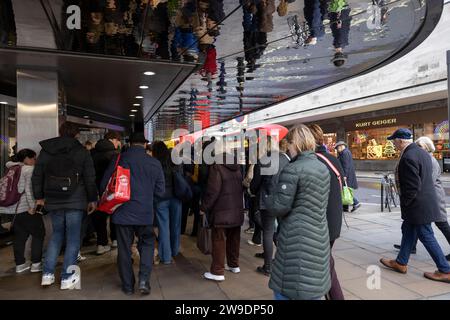 Weihnachtseinkäufer stehen vor dem Kaufhaus John Lewis entlang der Oxford Street am letzten großen Einkaufstag der Weihnachtszeit vor Weihnachten, Großbritannien Stockfoto