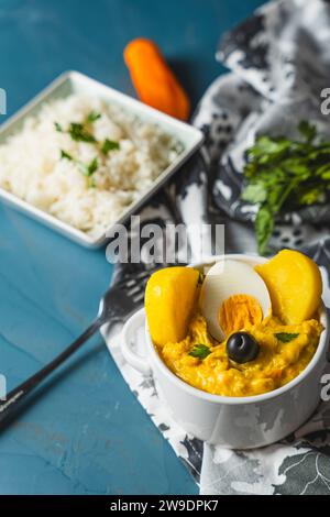 Traditionelles Gericht namens Aji de gallina mit einer Portion Reis, sehr beliebt in der peruanischen Gastronomie. Stockfoto