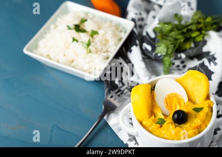 Traditionelles Gericht namens Aji de gallina mit einer Portion Reis, sehr beliebt in der peruanischen Gastronomie. Stockfoto