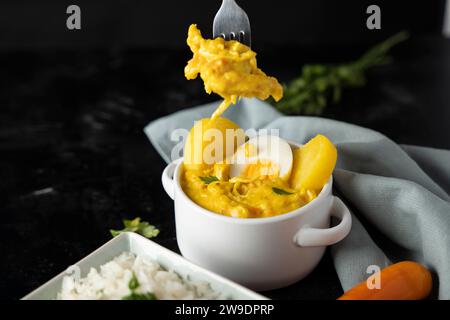 Gabel mit einem Stück Hühner aus einem typischen peruanischen Gericht. Stockfoto