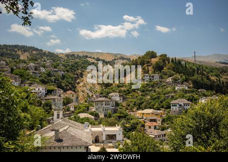 Wunderschöne hügelige Stadt Gjirokastër in Südalbanien. Balkan UNESCO Blick auf ein Dorf auf einem Hügel mit Bäumen. Stockfoto