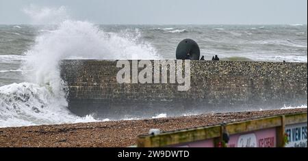 Brighton UK 27. Dezember 2023 - die Besucher werden nass, wenn die Wellen auf Brightons Küste stürzen, während Storm Gerrit Großbritannien heute attackiert Stockfoto