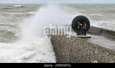 Brighton UK 27. Dezember 2023 - die Besucher werden nass, wenn die Wellen auf Brightons Küste stürzen, während Storm Gerrit Großbritannien heute attackiert Stockfoto