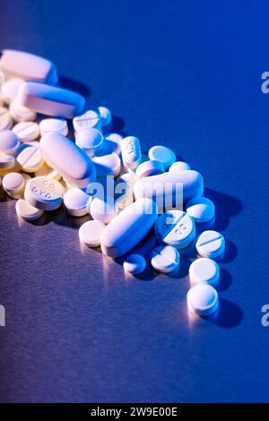 Weiße Pillen und Tabletten auf blauem Hintergrund Stockfoto