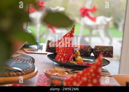 Weihnachtstisch-Einstellungen, mit Crackern, festlichen Dekorationen, Platzeinstellungen, bereit zum Essen, Weihnachtsessen Stockfoto