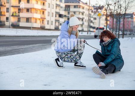 Ein Mädchen ist in den Schnee gefallen und hält ihr Bein. Stockfoto