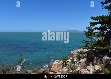 Blick auf das Meer mit Granitfelsen und Eiskiefern auf dem Gabul Way Coastal Walkway zwischen Nelly Bay und Geoffrey Bay, Magnetic Island, Queensland, Australien Stockfoto