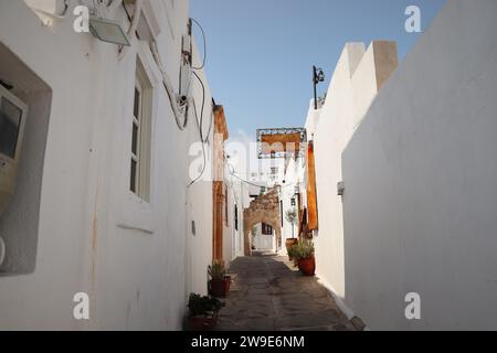 Enge Straße in Lindos Stadt auf Rhodos Insel, Dodekanese, Griechenland. Schöne schöne alte weiße Häuser. Berühmtes Touristenziel in Süd-EUR Stockfoto