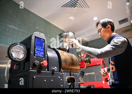 (231227) -- CHANGCHUN, 27. Dezember 2023 (Xinhua) -- Woo Kyong-Jei, ein südkoreanischer Barista, röstet Kaffeebohnen in einem Café in Changchun, nordöstliche chinesische Provinz Jilin, 27. Dezember 2023. In den letzten Jahren hat der Nordosten die innovationsorientierte Entwicklungsstrategie aktiv umgesetzt. Viele ausländische Freunde haben Chancen erkannt und beschlossen, sich hier niederzulassen, um ihren Träumen nachzugehen. Sie leben in der Region, haben die rasche wirtschaftliche und soziale Entwicklung erlebt und haben inzwischen ihre eigenen Anstrengungen zur vollständigen Wiederbelebung des Nordostchinesischen beigetragen. (Xinhua/Yan Linyun) Stockfoto