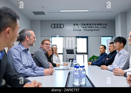 (231227) -- CHANGCHUN, 27. Dezember 2023 (Xinhua) -- die deutschen Ingenieure Sascha Schuerrer (3. L) und seine Frau Johanna Garzon-Schuerrer (4. L) treffen sich am 24. November 2023 in einem Konferenzraum in der Audi FAW NEV Co., Ltd. In Changchun, nordöstliche Provinz Jilin. In den letzten Jahren hat der Nordosten die innovationsorientierte Entwicklungsstrategie aktiv umgesetzt. Viele ausländische Freunde haben Chancen erkannt und beschlossen, sich hier niederzulassen, um ihren Träumen nachzugehen. Sie leben in der Region und haben die rasche wirtschaftliche und soziale Entwicklung erlebt und inzwischen eigene Anstrengungen geleistet Stockfoto