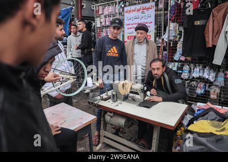 Ein palästinensischer Schneider namens Abu Adam Dolah verwendet eine Nähmaschine mit Pedalbedienung, die er aufgrund von Stromknappheit entwickelt Hat Ein palästinensischer Schneider namens Abu Adam Dolah verwendet eine Nähmaschine mit Pedalbedienung, die er aufgrund von Stromknappheit entwickelt hat, da Israel am 27. Dezember 2023 in Rafah, Gaza, die Macht blockiert. Gashda befestigte Fahrradpedale an seiner Nähmaschine so, dass er die Maschine ohne Strom benutzen konnte. Foto: Bashar Taleb apaimages Rafah Gazastreifen palästinensisches Gebiet 271223 Rafah BT 001 Copyright: XapaimagesxBasharxTalebxapaimagesx Stockfoto