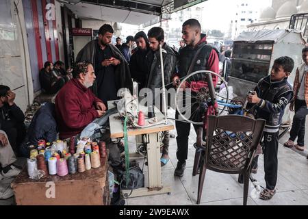 Ein palästinensischer Schneider namens Abu Adam Dolah verwendet eine Nähmaschine mit Pedalbedienung, die er aufgrund von Stromknappheit entwickelt Hat Ein palästinensischer Schneider namens Abu Adam Dolah verwendet eine Nähmaschine mit Pedalbedienung, die er aufgrund von Stromknappheit entwickelt hat, da Israel am 27. Dezember 2023 in Rafah, Gaza, die Macht blockiert. Gashda befestigte Fahrradpedale an seiner Nähmaschine so, dass er die Maschine ohne Strom benutzen konnte. Foto: Bashar Taleb apaimages Rafah Gazastreifen palästinensisches Gebiet 271223 Rafah BT 0012 Copyright: XapaimagesxBasharxTalebxapaimagesx Stockfoto