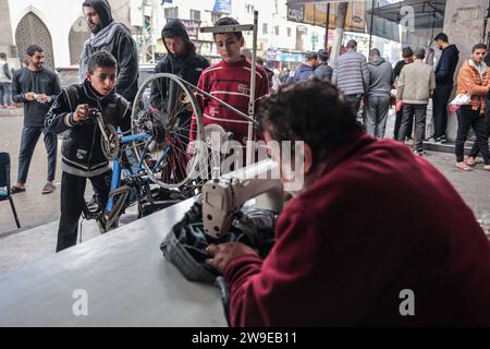 Ein palästinensischer Schneider namens Abu Adam Dolah verwendet eine Nähmaschine mit Pedalbedienung, die er aufgrund von Stromknappheit entwickelt Hat Ein palästinensischer Schneider namens Abu Adam Dolah verwendet eine Nähmaschine mit Pedalbedienung, die er aufgrund von Stromknappheit entwickelt hat, da Israel am 27. Dezember 2023 in Rafah, Gaza, die Macht blockiert. Gashda befestigte Fahrradpedale an seiner Nähmaschine so, dass er die Maschine ohne Strom benutzen konnte. Foto: Bashar Taleb apaimages Rafah Gazastreifen palästinensisches Gebiet 271223 Rafah BT 0020 Copyright: XapaimagesxBasharxTalebxapaimagesx Stockfoto