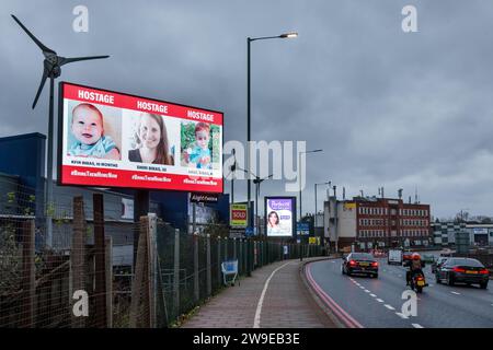 Propeller Park, 400 North Circular Road, 27. Dezember 2023. Eine rotierende digitale Plakatkampagne des "Geiseln- und Vermisstenfamilien Forum UK", in der Fotos von einigen der entführten israelischen Zivilisten gezeigt werden, die am 7. Oktober 2023 von der Hamas aufgenommen wurden. Die Kampagne zielt darauf ab, die Not der Männer, Frauen und Kinder, die noch immer als Geiseln im Gazastreifen gehalten werden, in die Öffentlichkeit zu rücken. Foto: Amanda Rose/Alamy Live News Stockfoto